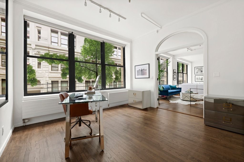 a workspace with wooden floor and a window