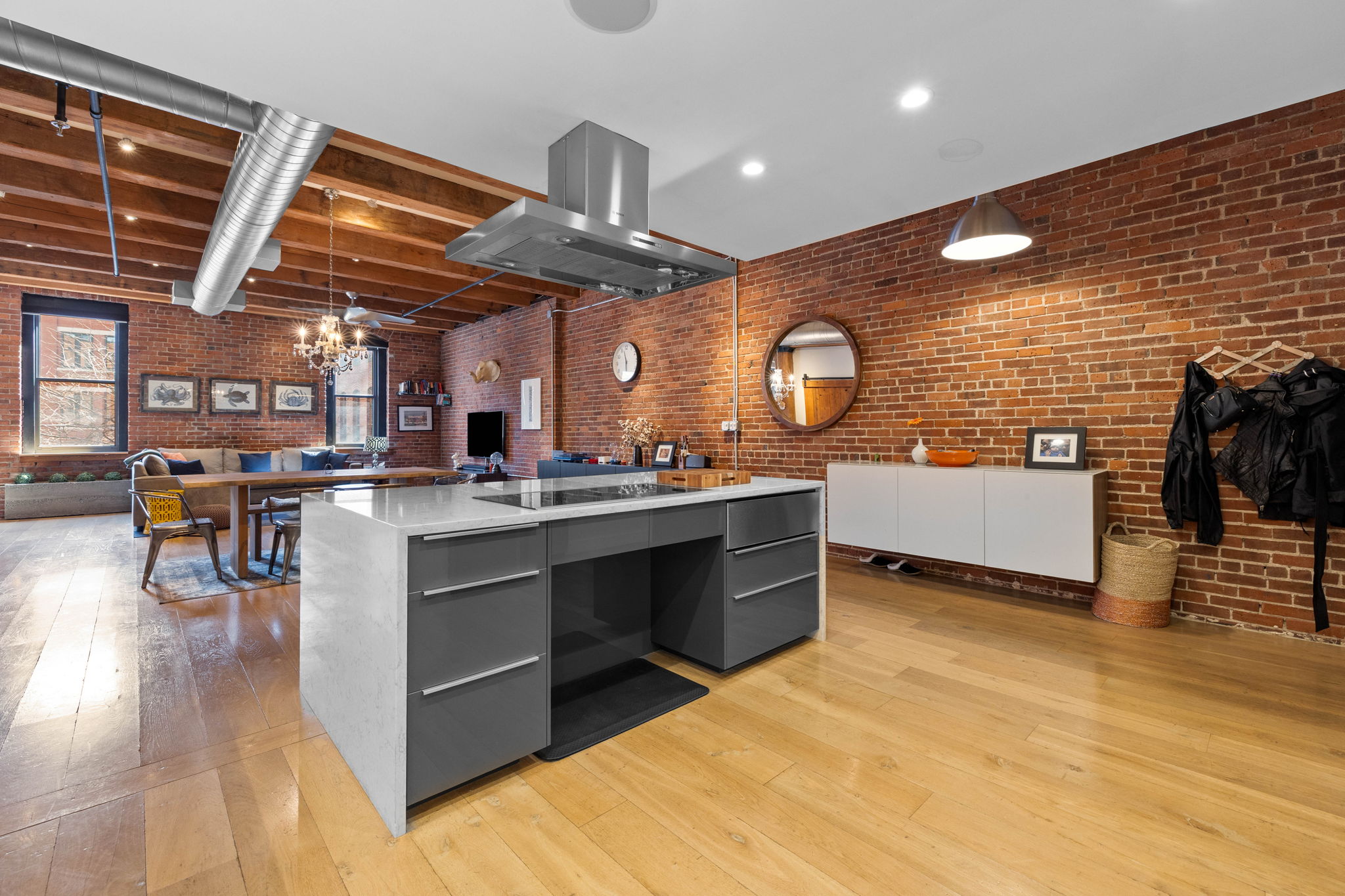 33 Sleeper Street, Unit 307 Boston, MA 02210 - Photo 4 of 15 a living room with stainless steel appliances kitchen island granite countertop lots of wooden cabinets a dining table and chairs