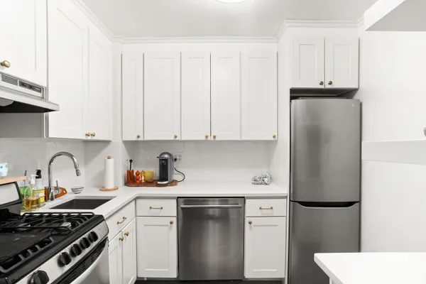 a kitchen with stainless steel appliances a refrigerator sink and cabinets