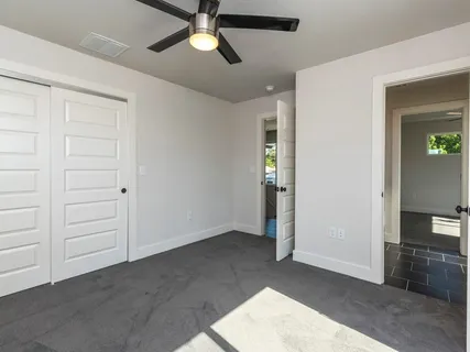 an empty room with closet and fan