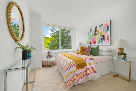 a bedroom with a bed and a painting on the wall