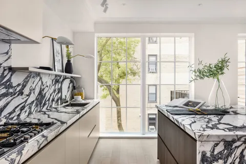 a kitchen with a stove and a wooden floor