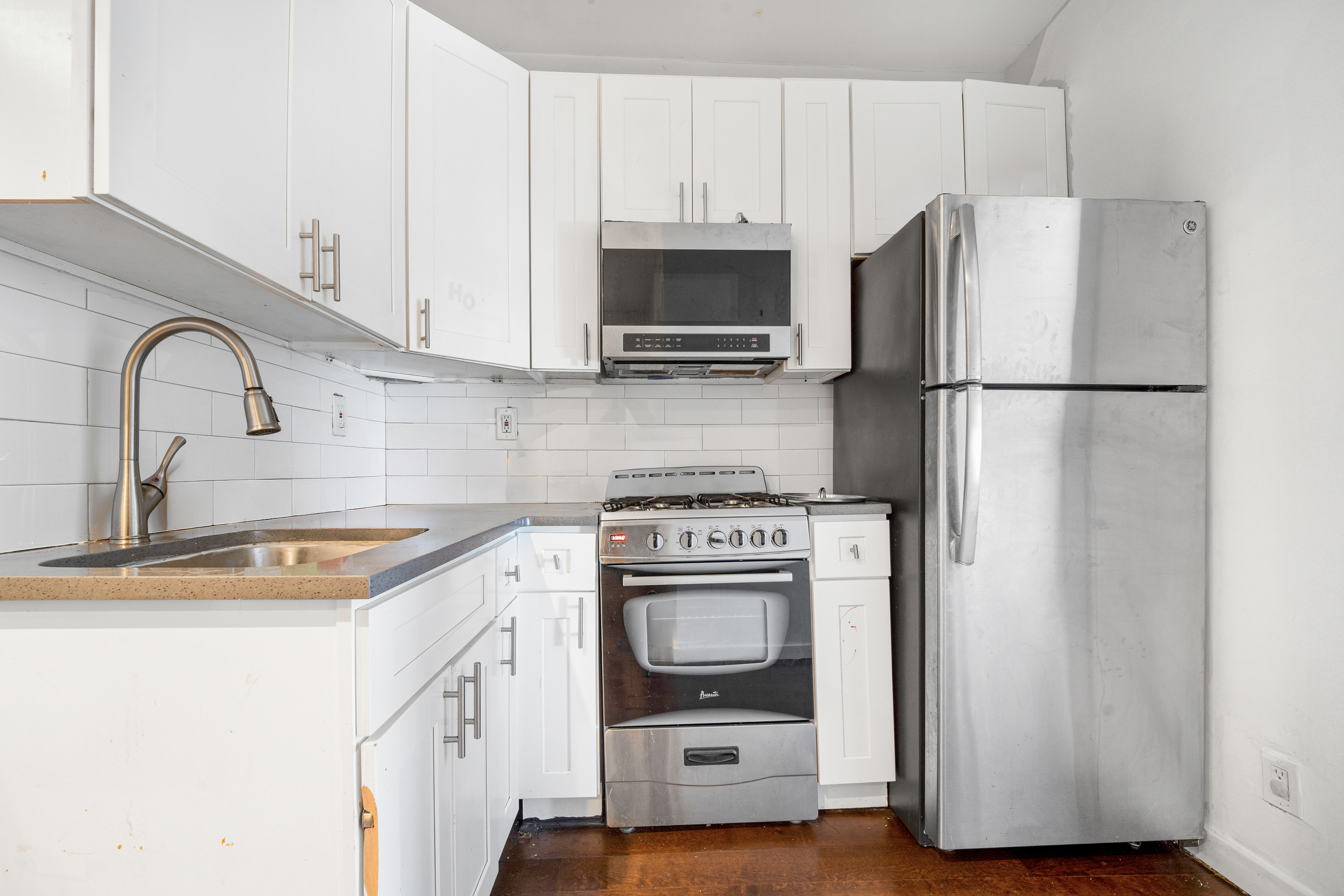 71-18 Myrtle Avenue Queens, NY 11385 - Photo 6 of 13 a kitchen with stainless steel appliances a refrigerator stove and sink