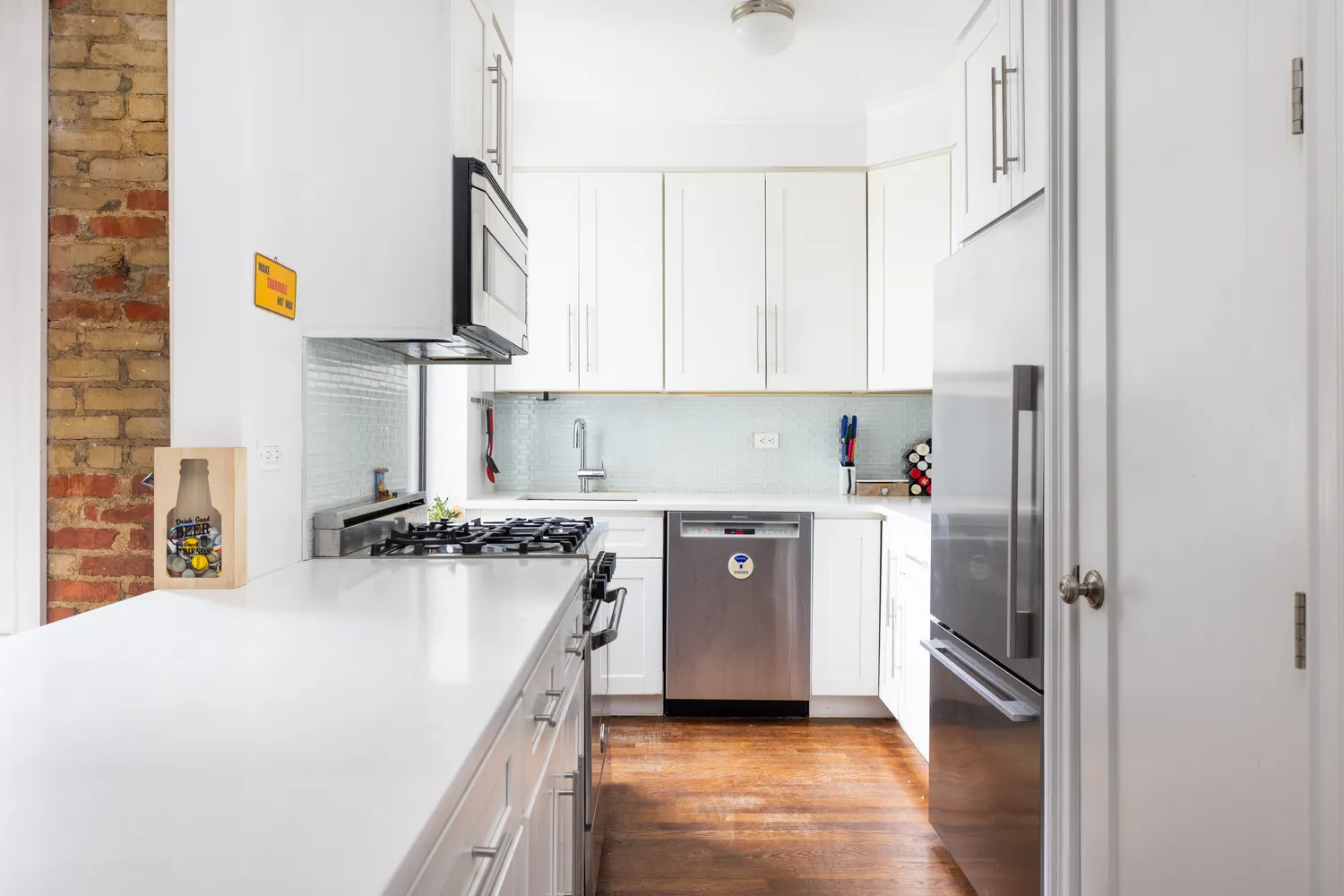 a kitchen with stainless steel appliances granite countertop a refrigerator a stove and a sink with wooden floor