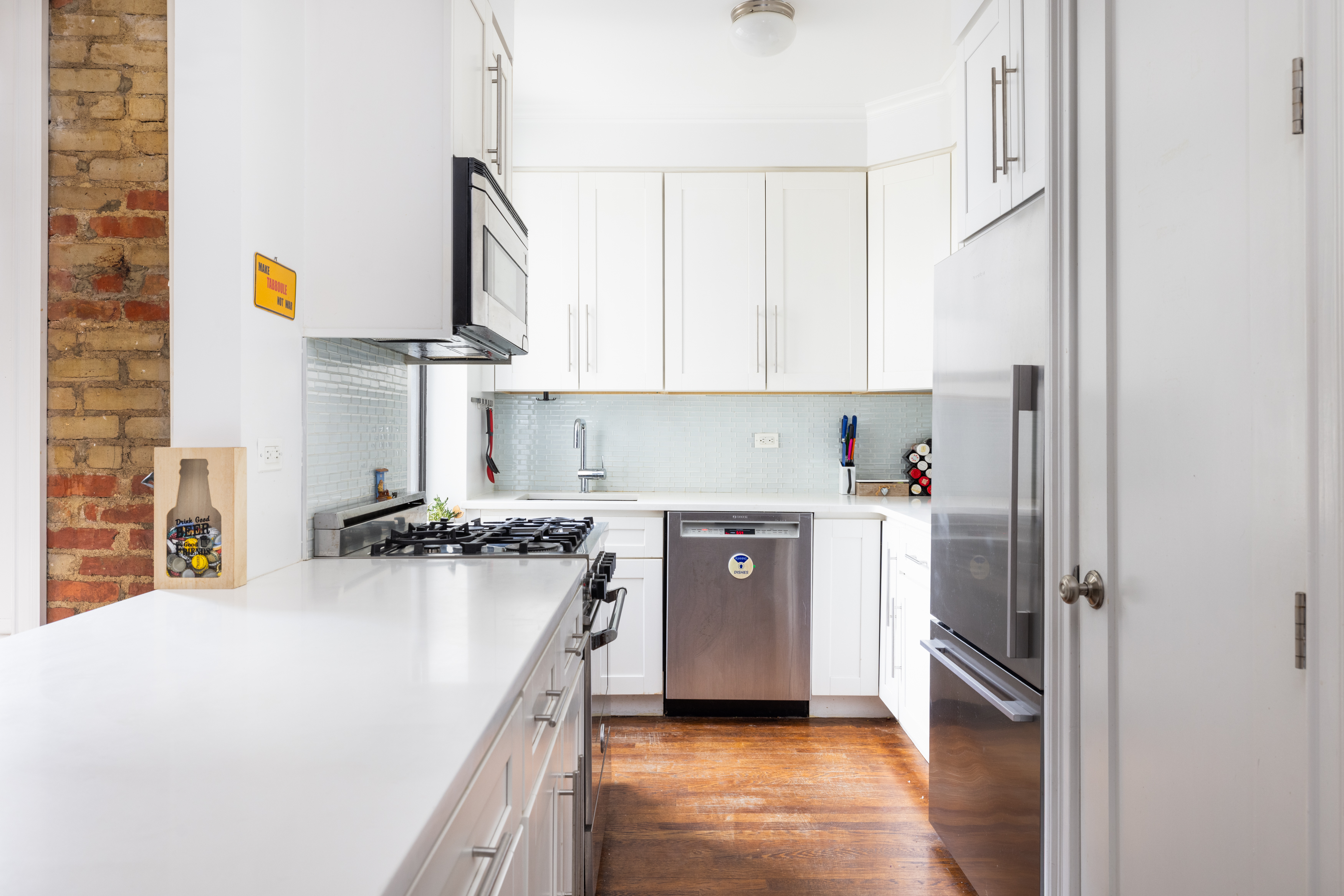 a kitchen with stainless steel appliances granite countertop a refrigerator a stove and a sink with wooden floor