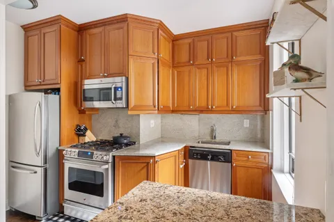 a kitchen with stainless steel appliances granite countertop a refrigerator stove and sink