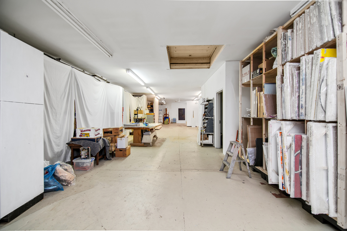 5-38 47th Road Queens, NY 11101 - Photo 9 of 14 a living room with lots of furniture and a book shelf