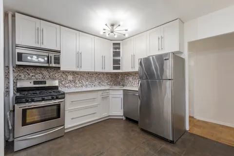 a kitchen with refrigerator stove microwave and cabinets