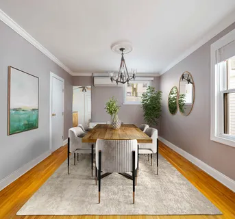 a view of a dining room with furniture a rug and wooden floor