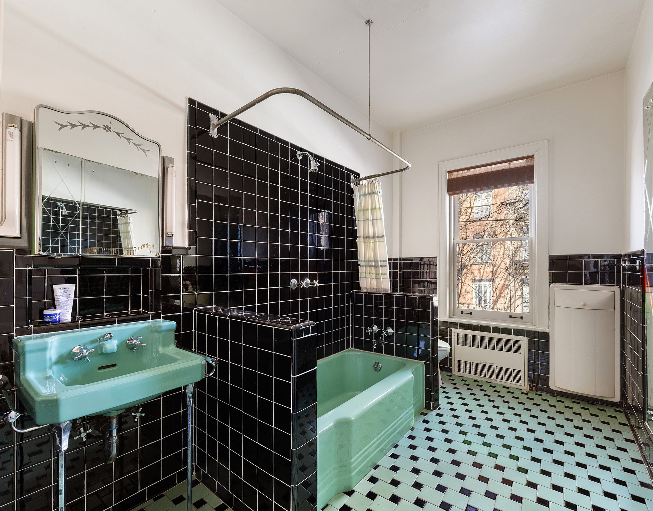 323 Garfield Place Brooklyn, NY 11215 - Photo 11 of 14 a bathroom with a black white checkered floor with a sink a mirror and a shower