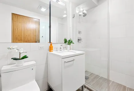 a bathroom with a sink a toilet and shower