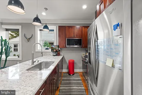 a kitchen with stainless steel appliances granite countertop a sink and a refrigerator