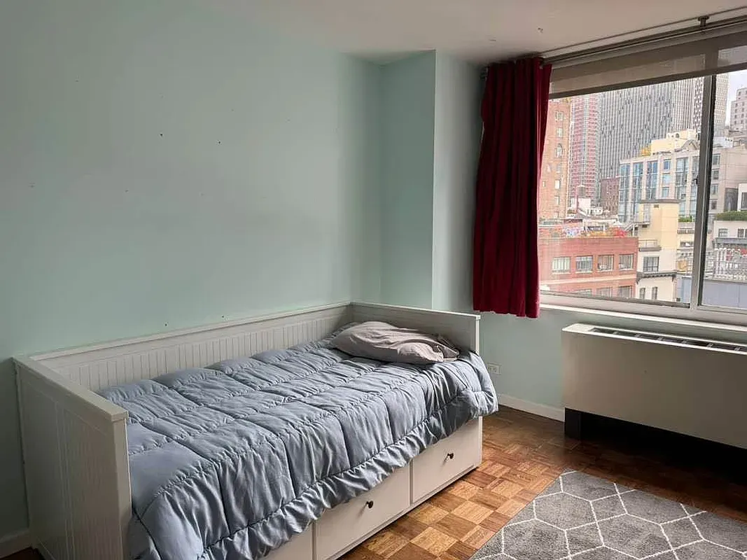 a bed sitting in a bedroom next to a window