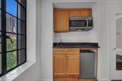 a kitchen with stainless steel appliances granite countertop a stove a microwave and a sink