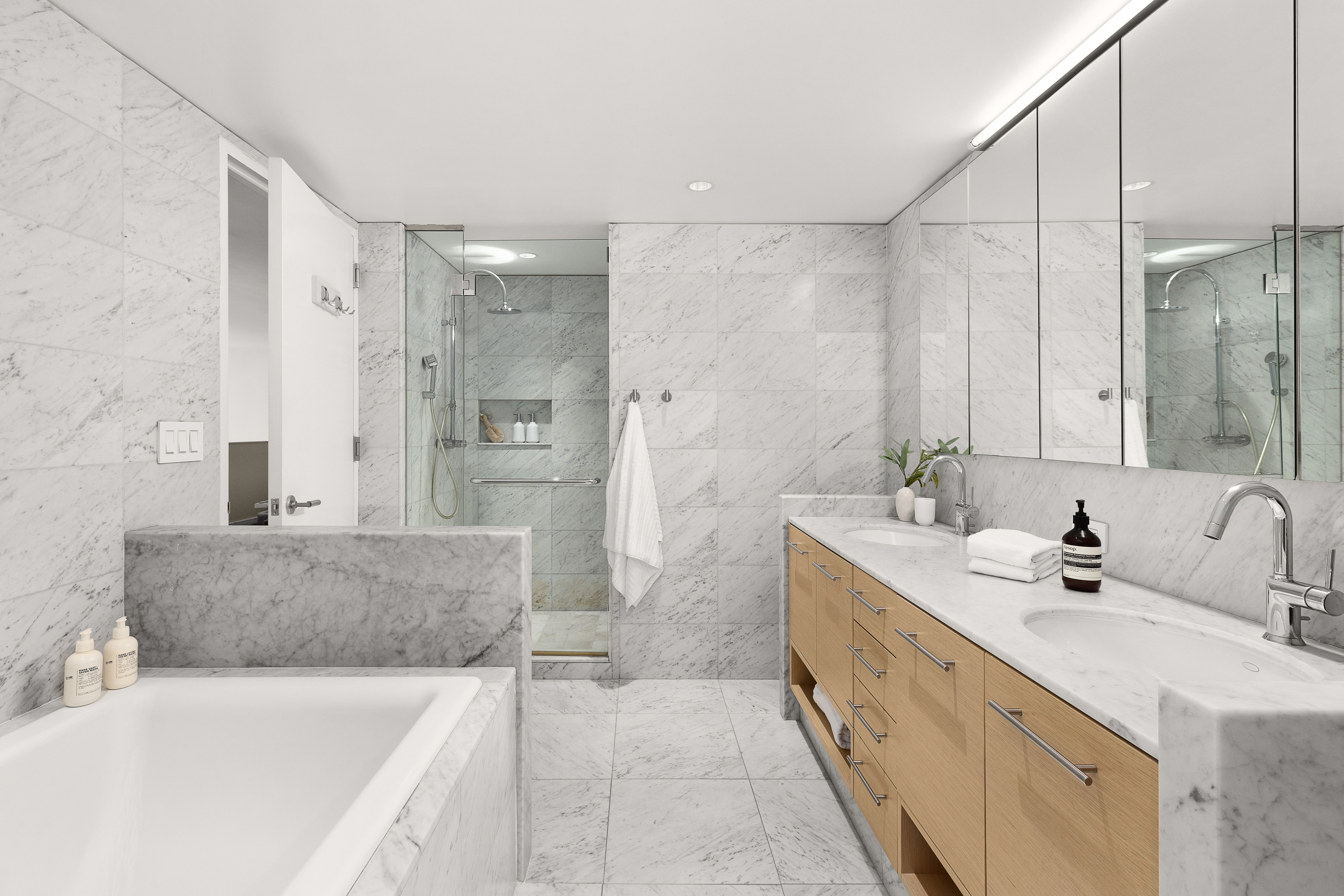 310 East 53rd Street, Unit 2/3D Manhattan, NY 10022 - Photo 10 of 13 a bathroom with a tub sink and mirror