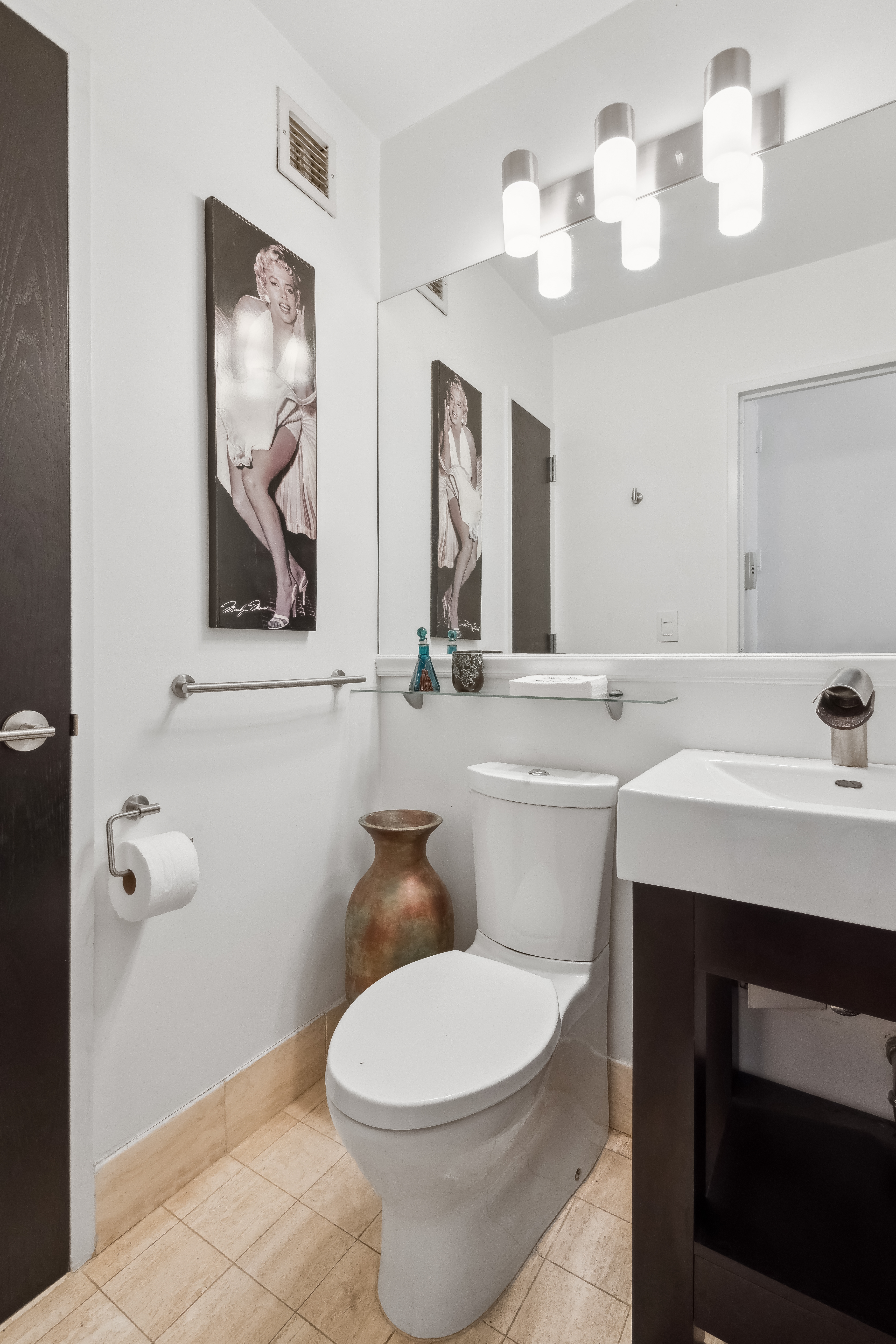 200 East 61st Street, Unit 18A Manhattan, NY 10065 - Photo 5 of 9 a bathroom with a sink mirror and toilet