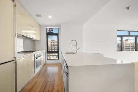 a kitchen with kitchen island a counter top space a sink and stainless steel appliances