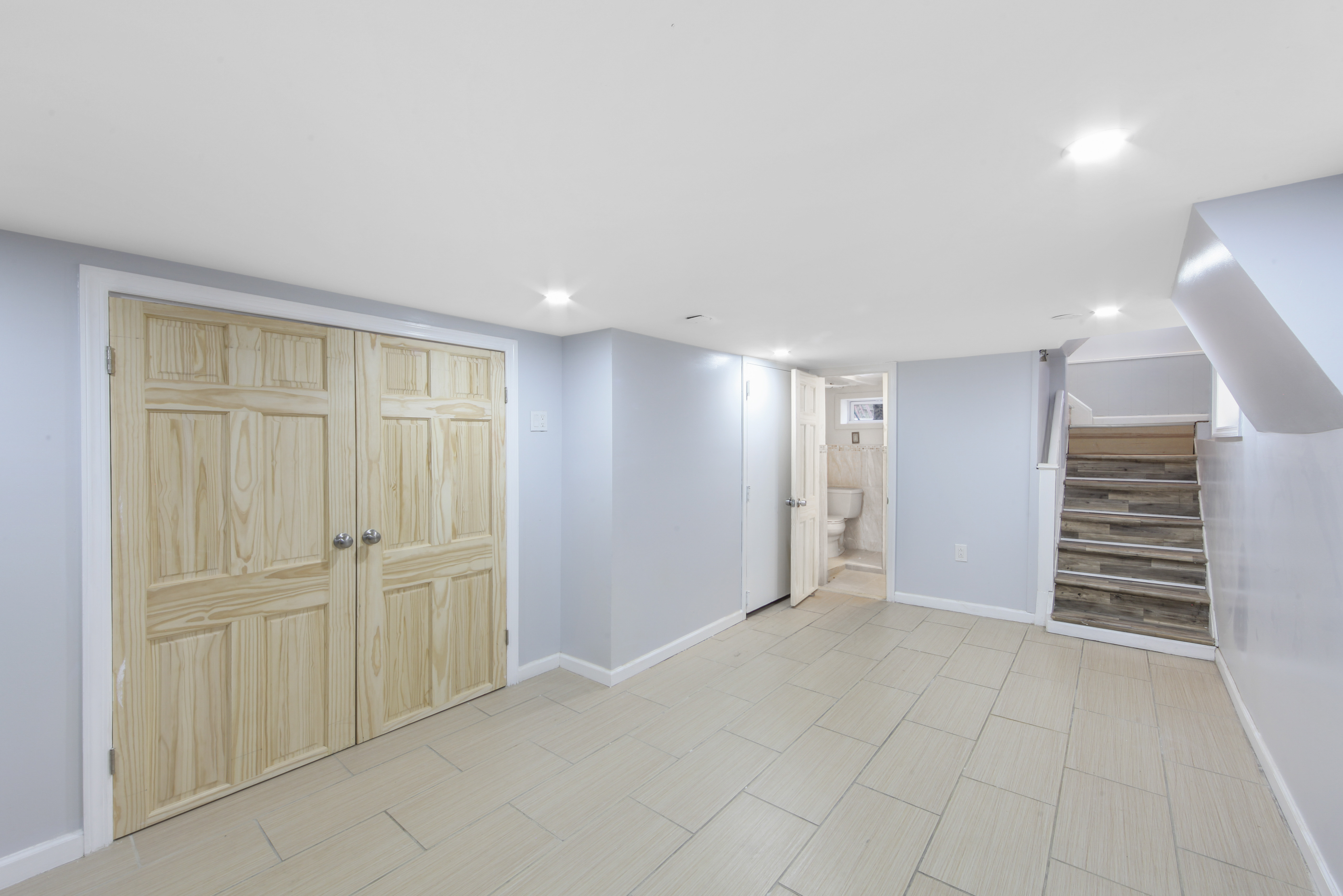 1530 East 51st Street Brooklyn, NY 11234 - Photo 8 of 14 an empty room with windows and staircase