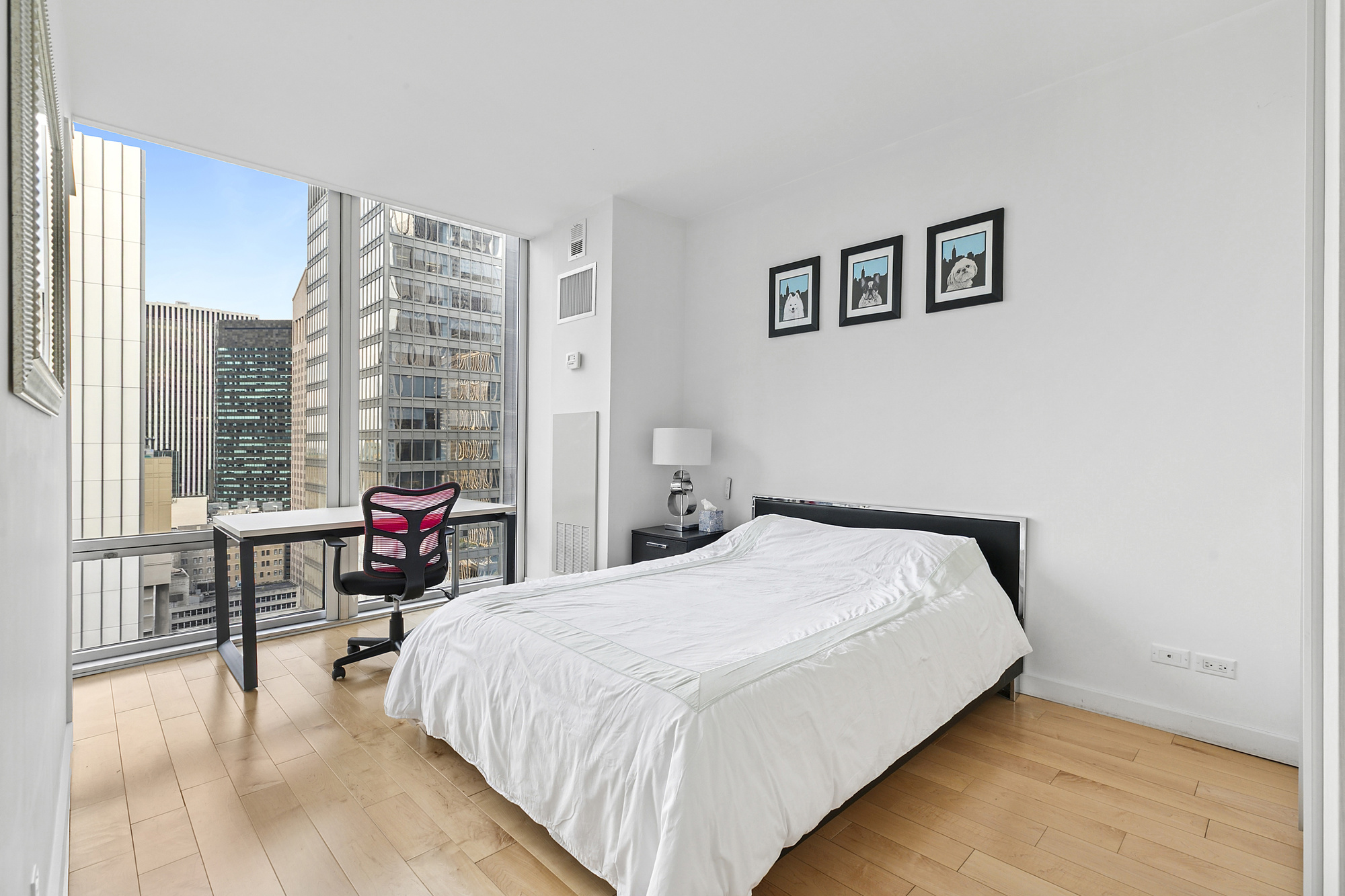 641 5th Avenue, Unit 28B Manhattan, NY 10022 - Photo 5 of 11 a bedroom with a bed and a table
