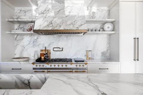 a large kitchen with kitchen island a large counter top space a sink a stove and a window