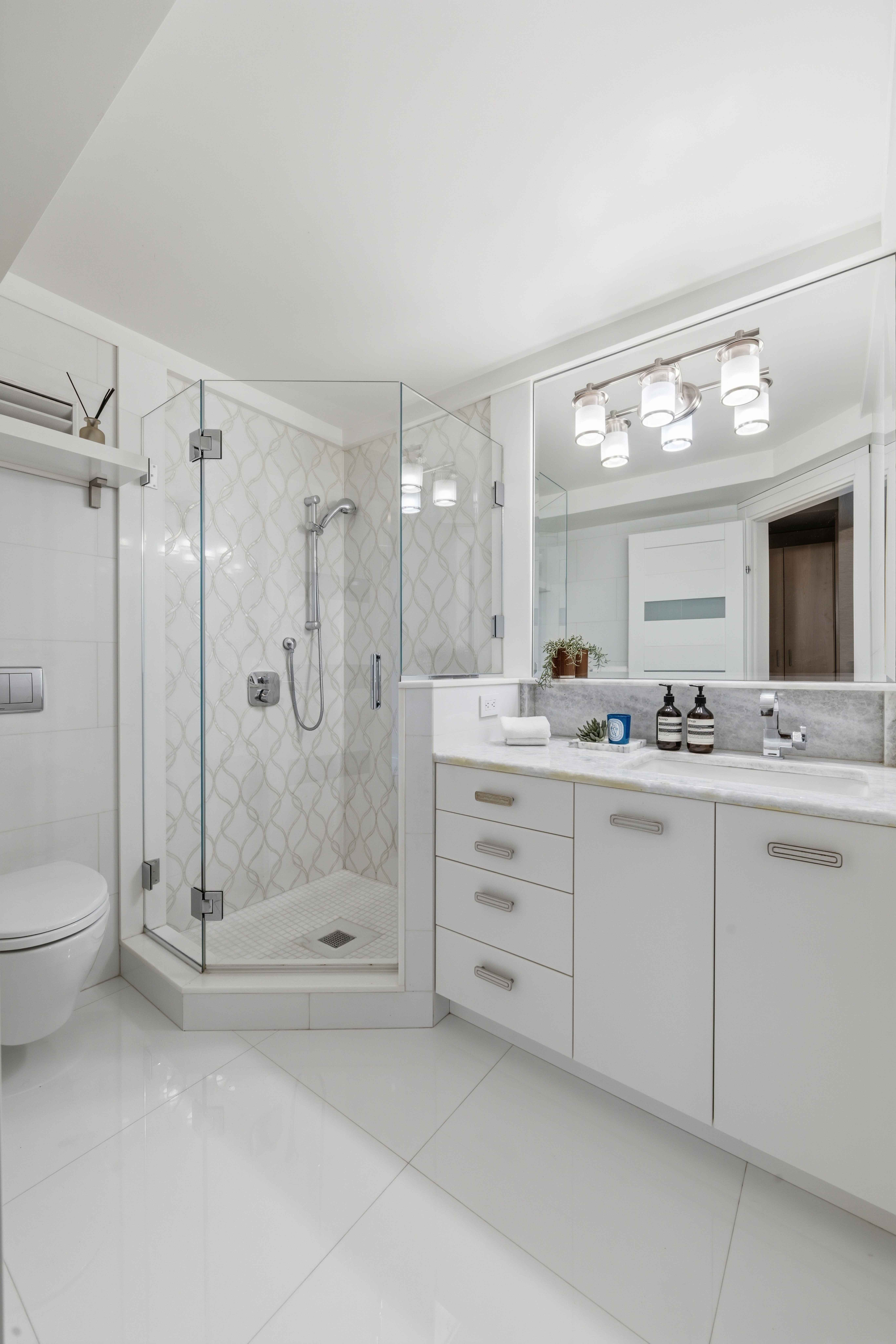 40 East 78th Street, Unit 5E Manhattan, NY 10075 - Photo 12 of 23 a bathroom with a shower a sink and a mirror