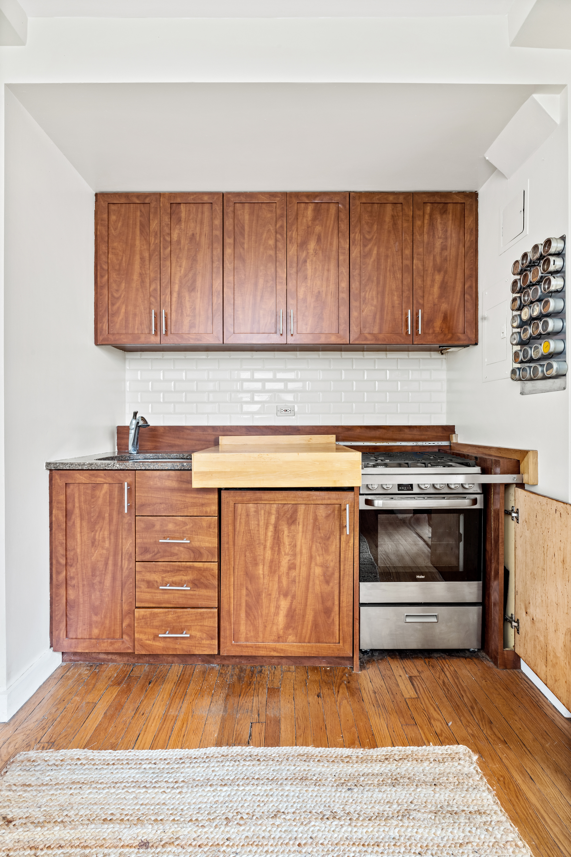 136 East 36th Street, Unit 5D Manhattan, NY 10016 - Photo 4 of 13 a kitchen with wooden cabinets and a stove top oven