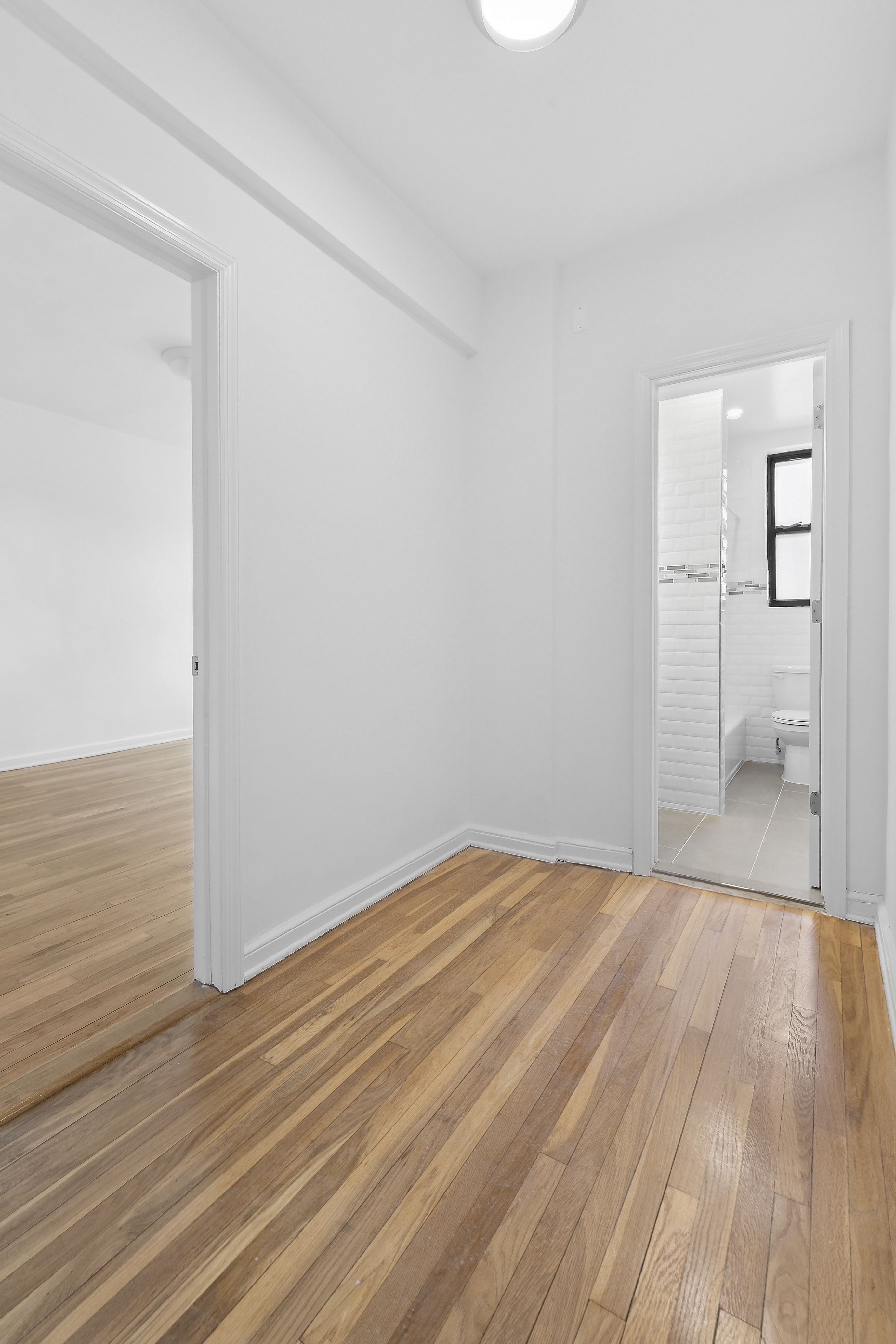 159-34 Riverside Drive West, Unit 5F90 Manhattan, NY 10032 - Photo 8 of 23 a view of a room with wooden floor and a toilet