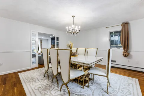 a view of a dining room with furniture and chandelier