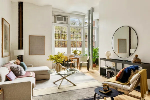 a living room with furniture a fireplace and a potted plant
