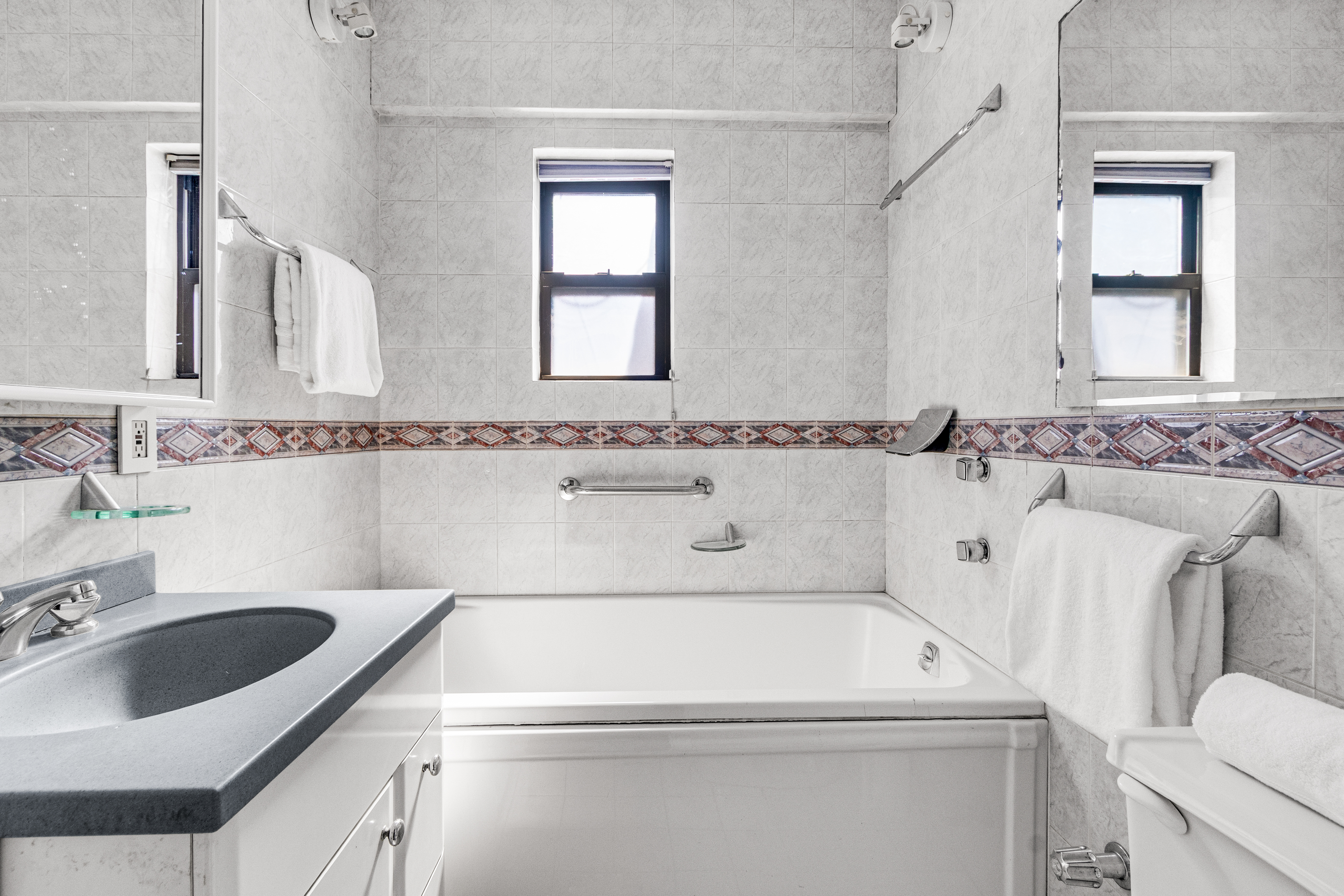 345 East 52nd Street, Unit 10CD Manhattan, NY 10022 - Photo 10 of 14 a bathroom with a sink and a washing machine with double vanity