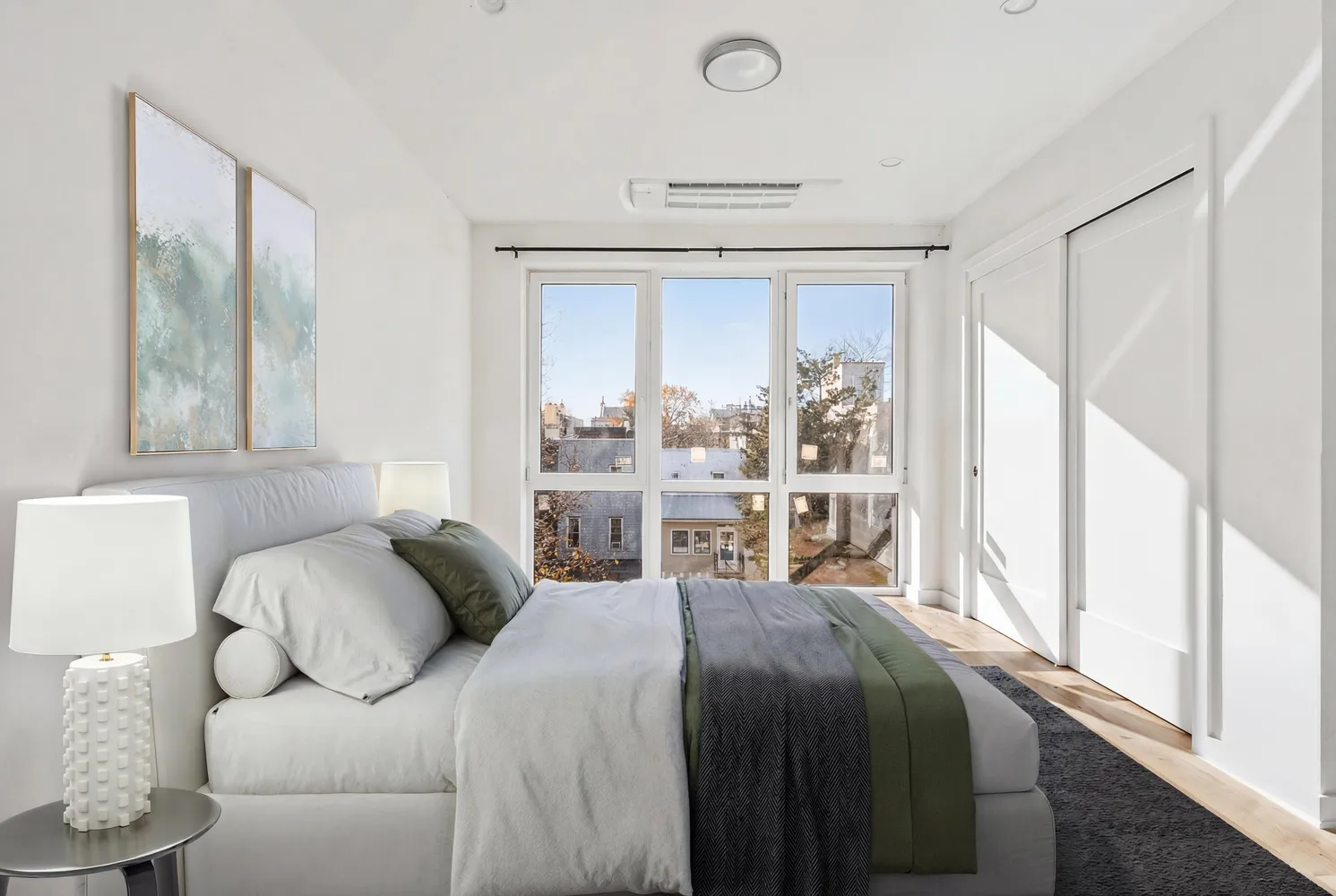 a bedroom with a bed and a large window