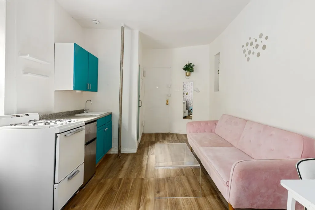 a living room with a couch and a stove with wooden floor