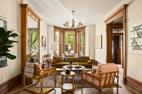 a dining room with furniture large windows a chandelier and wooden floor