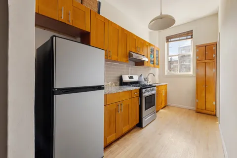 a kitchen with stainless steel appliances a refrigerator a stove a sink and a refrigerator