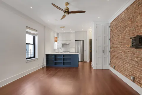 a kitchen with stainless steel appliances kitchen island wooden floors and view living room