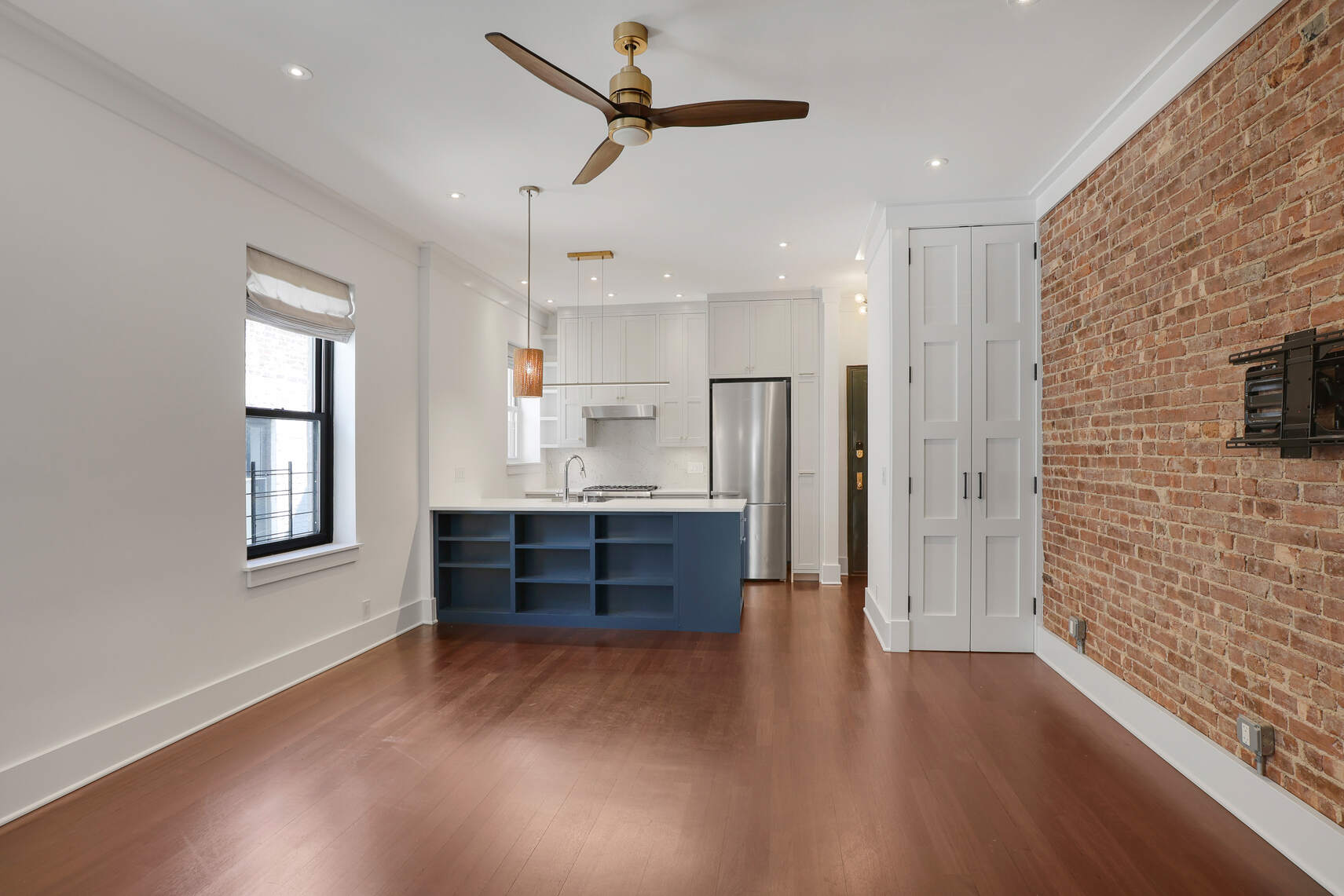 133 East 30th Street, Unit PH5B Manhattan, NY 10016 - Photo 16 of 24 a kitchen with stainless steel appliances kitchen island wooden floors and view living room