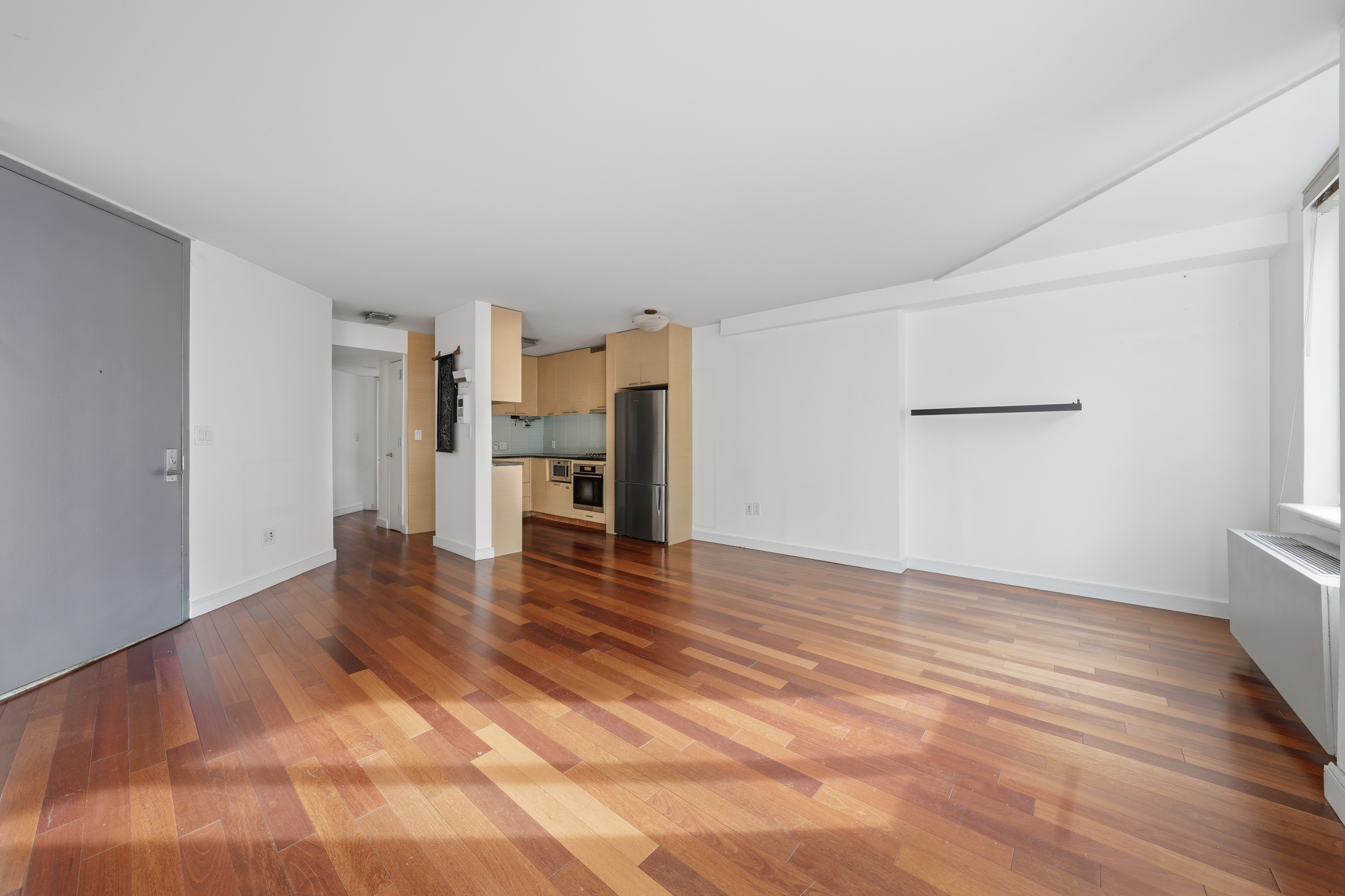 206 East 95th Street, Unit 6B Manhattan, NY 10128 - Photo 2 of 25 a view of empty room with kitchen and window