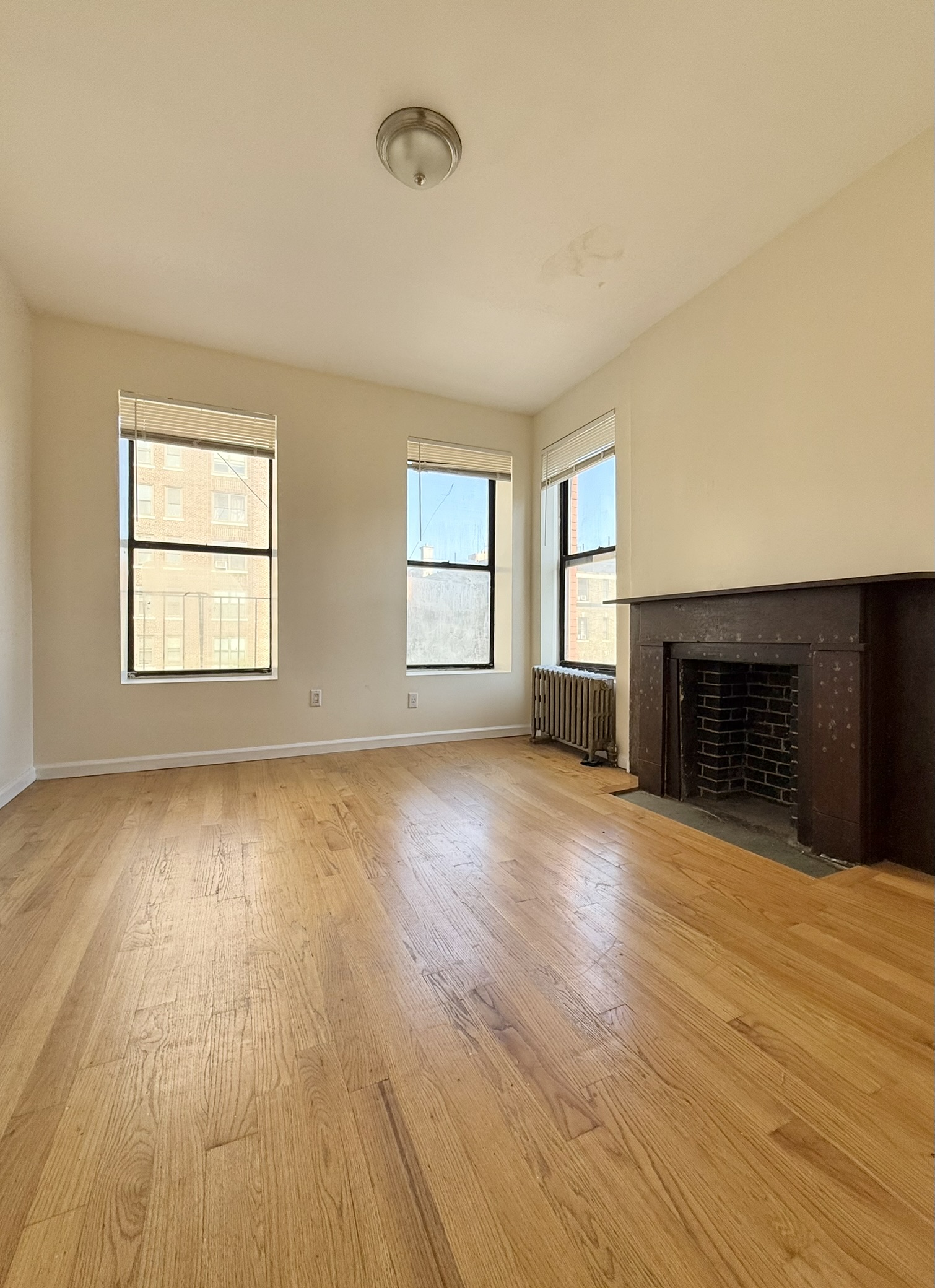 196 West 108th Street, Unit 5N Manhattan, NY 10025 - Photo 2 of 5 a view of an empty room with wooden floor and a window