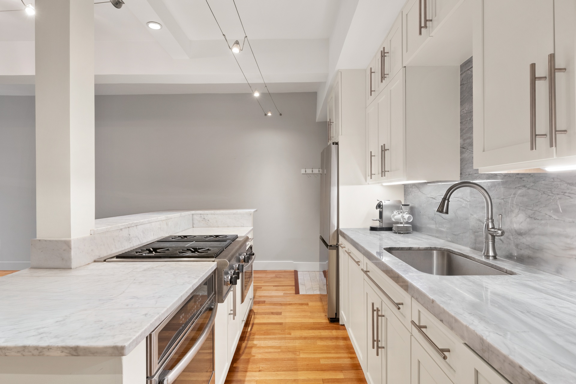 135 West 70th Street, Unit 4A Manhattan, NY 10023 - Photo 4 of 7 a kitchen with stainless steel appliances granite countertop a sink a stove and a refrigerator