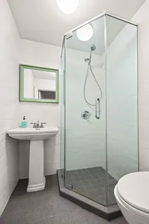 a bathroom with a sink toilet and shower