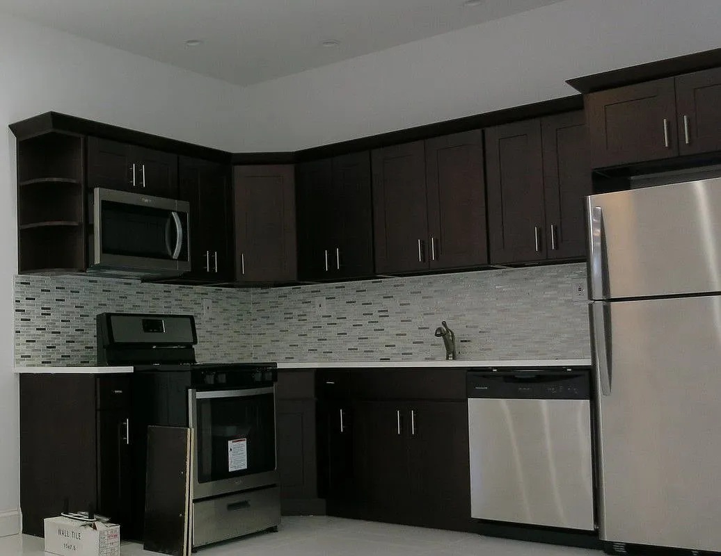 186 Howard Avenue Brooklyn, NY 11233 - Photo 7 of 14 a kitchen with granite countertop wood cabinets and black stainless steel appliances