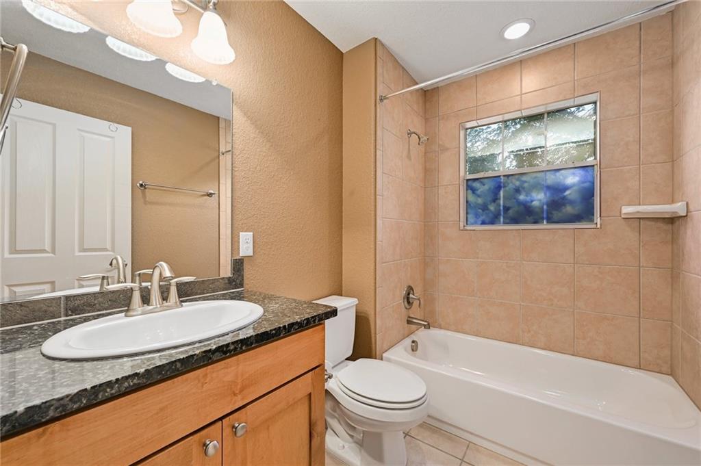 1102 Clermont Avenue Austin, TX 78702 - Photo 25 of 30 a bathroom with a granite countertop sink and a mirror