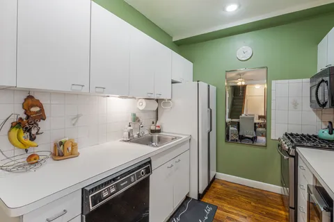 a kitchen with a sink a stove and cabinets