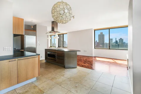 a kitchen with kitchen island granite countertop a stove and a sink