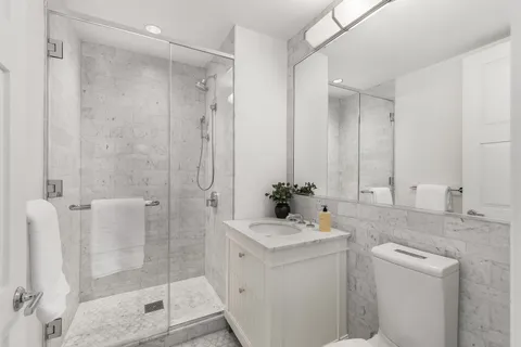 a bathroom with a shower sink and mirror
