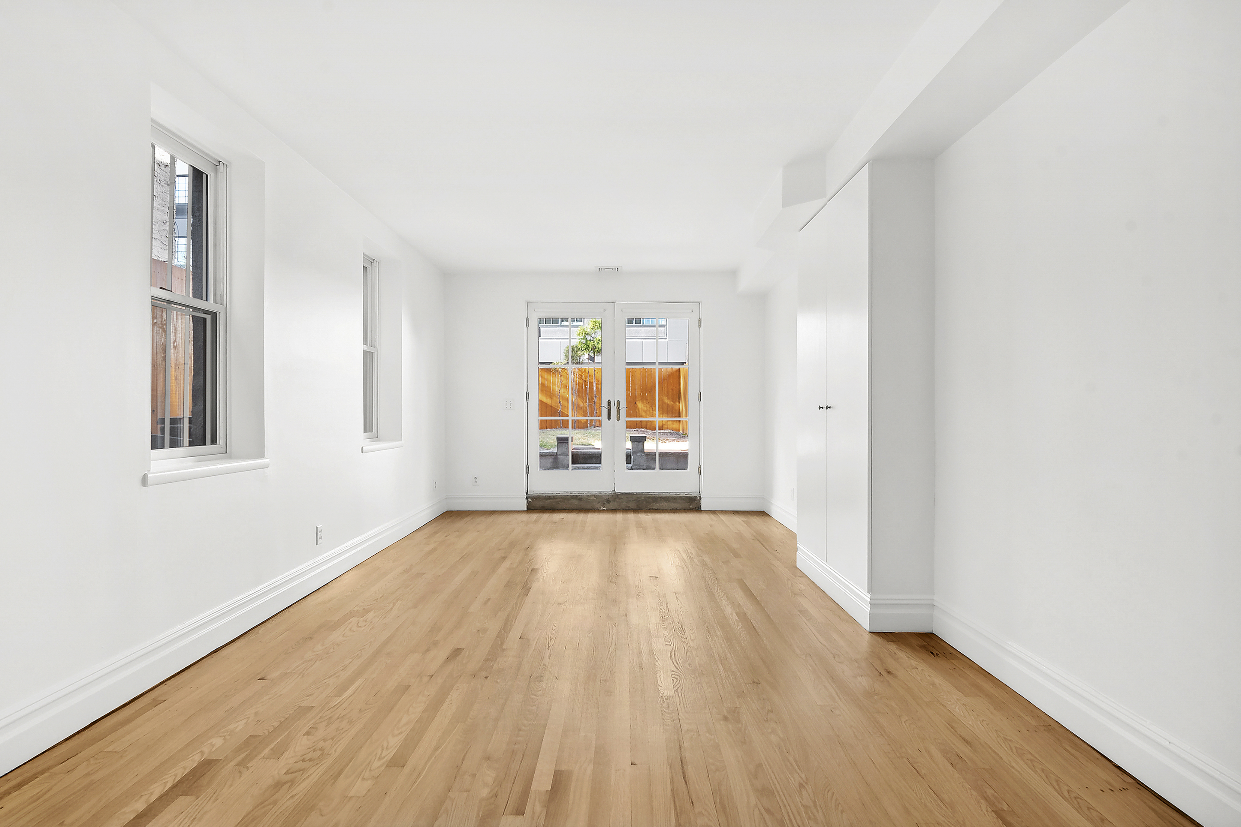 562 Washington Avenue, Unit 1 Brooklyn, NY 11238 - Photo 8 of 12 an empty room with wooden floor and windows