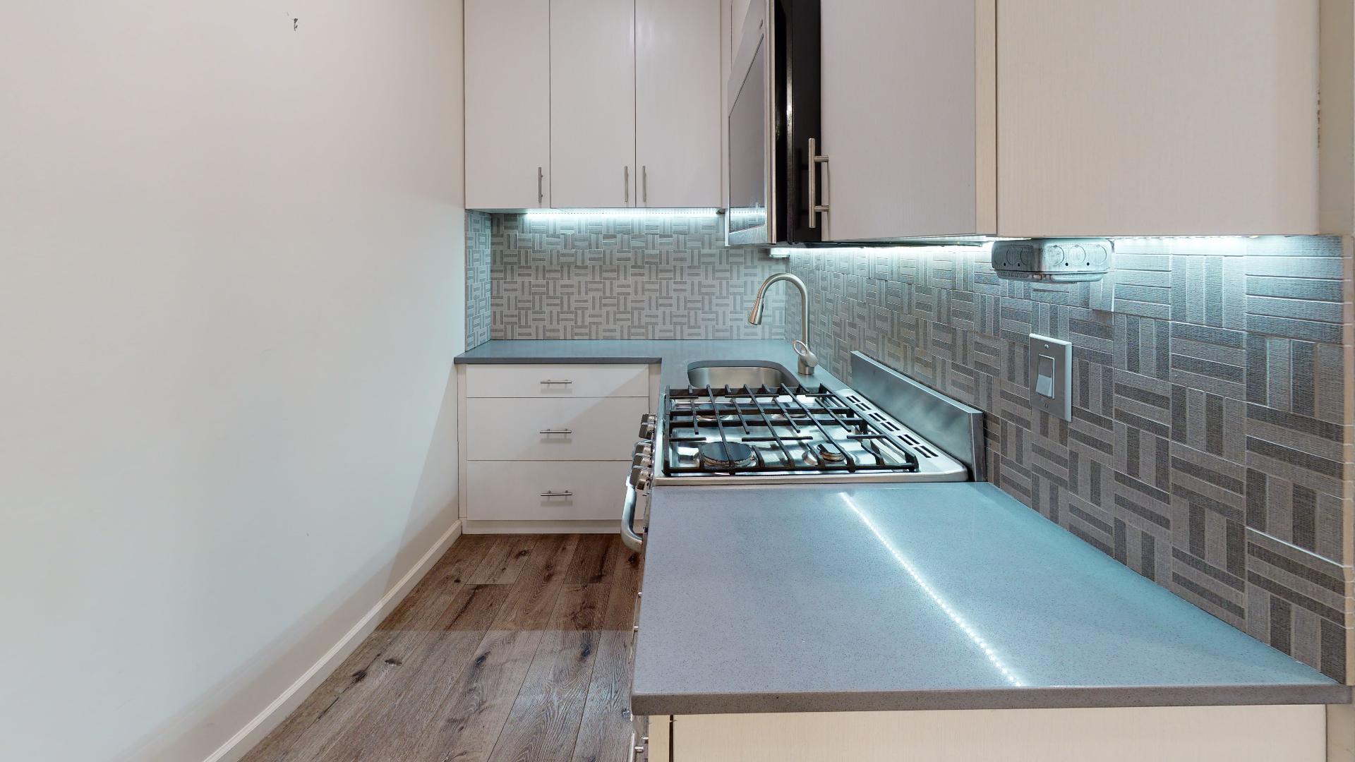 130 West 71st Street, Unit 1 Manhattan, NY 10023 - Photo 3 of 11 a kitchen with a sink stove and cabinets
