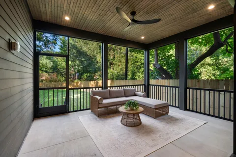 a view of a patio with chairs and floor to ceiling window
