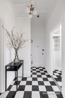 a room with a black white checkered floor with a black white checkered floor and a potted plant