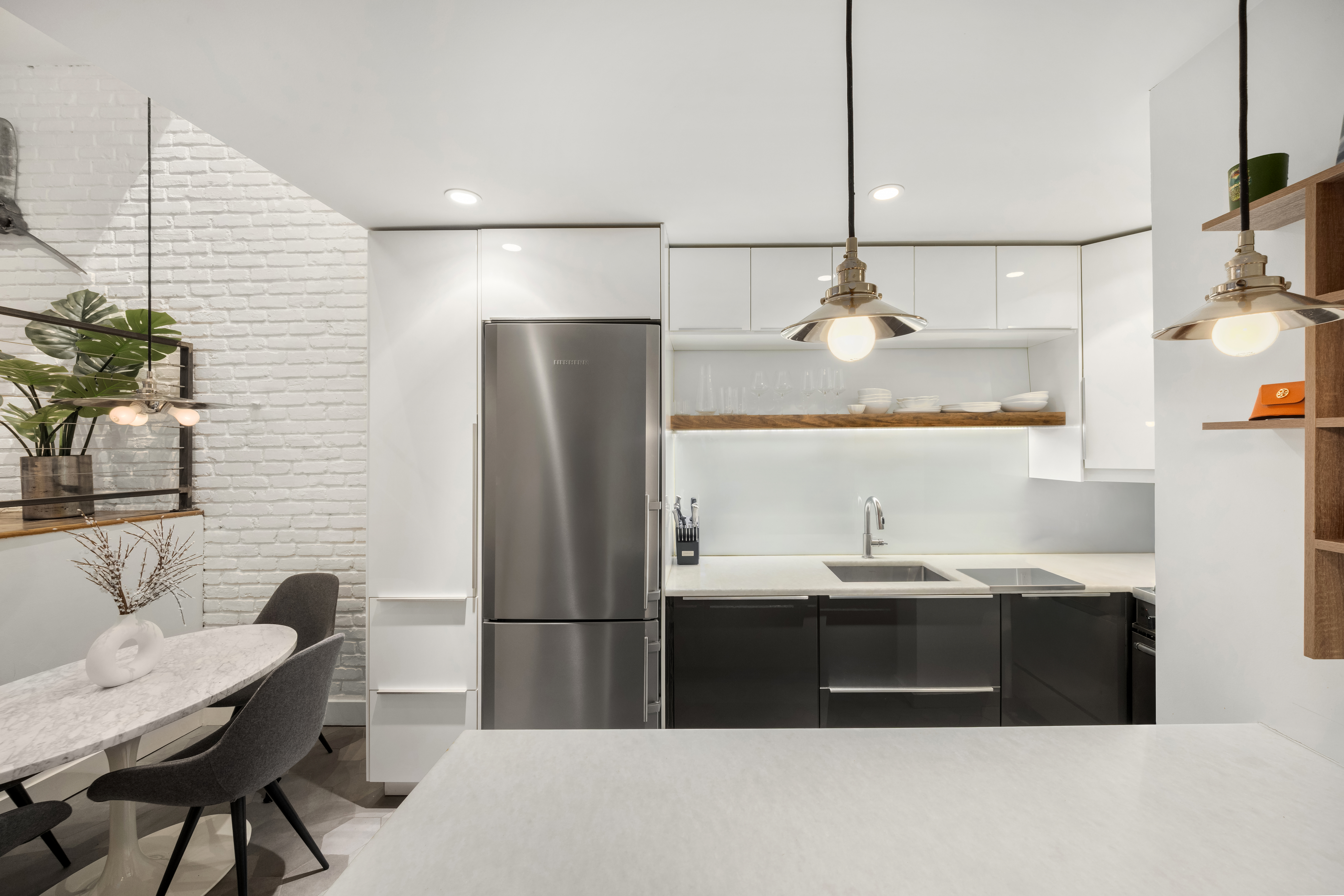 49 East 12th Street, Unit 2C Manhattan, NY 10003 - Photo 4 of 8 a bathroom with a sink a counter and chairs